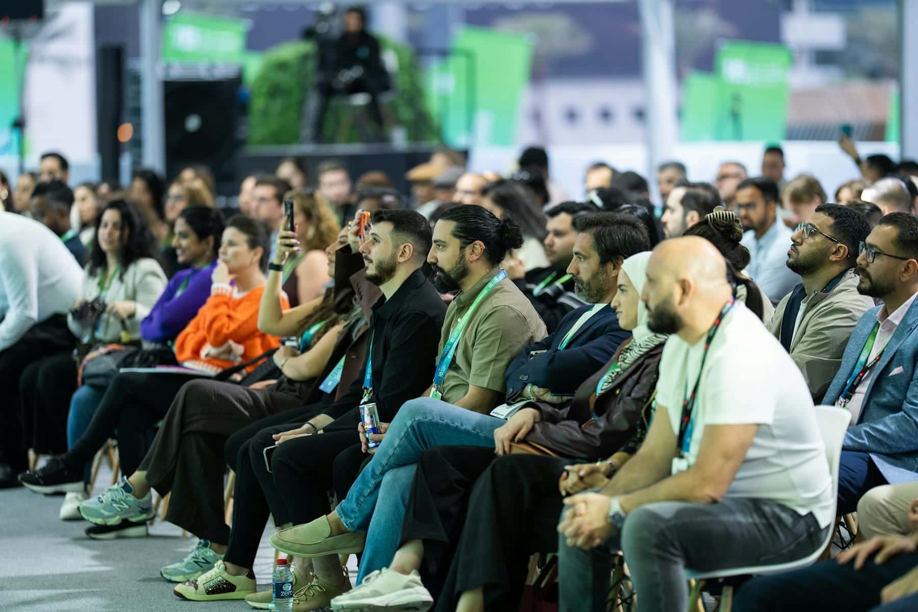 Attentive audience seated in rows at a busy conference session