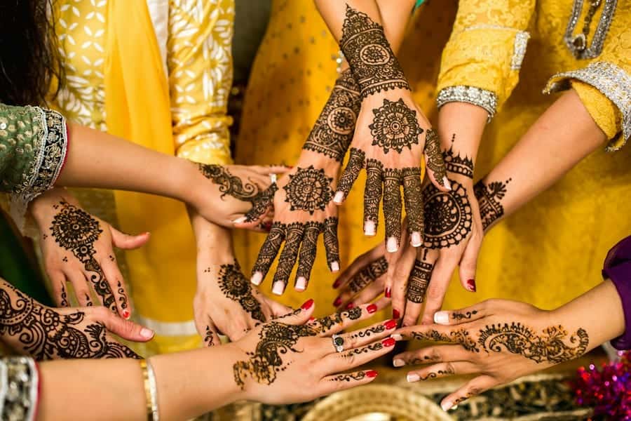 Hands decorated with intricate mehendi patterns joined together